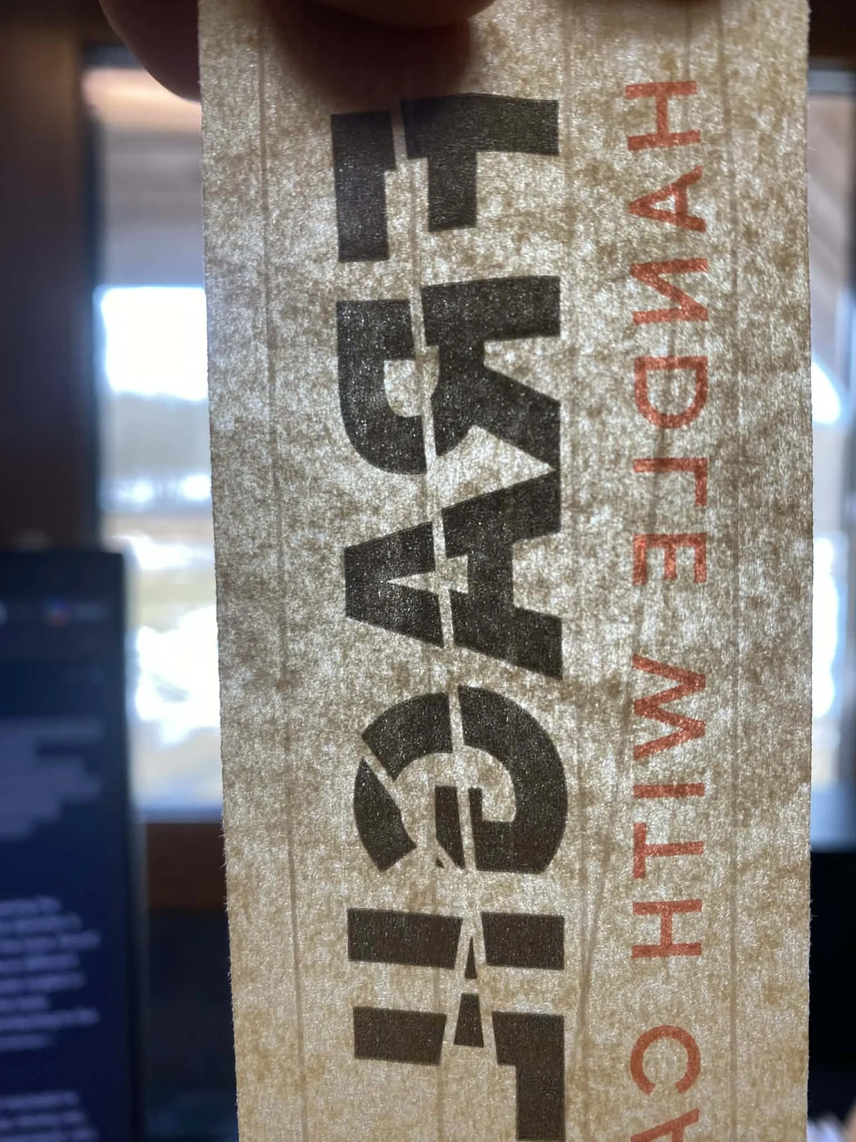 Närbild av brun förstärkt papperstejp med svart FRAGILE-tryck och röd text.